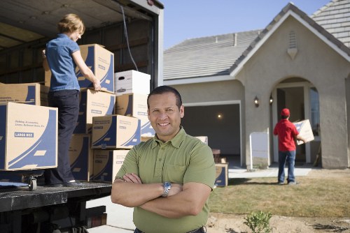 Movers carrying furniture through a Crystal Palace property